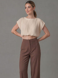 Blusa plisada beige para mujer con diseño elegante y ligero. Perfecta para crear looks sofisticados combinándola con pantalones de vestir o faldas para ocasiones formales o casuales.