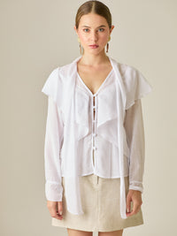Blusa de manga larga con detalle de volantes en el escote y lazo largo para anudar. Su diseño ligero y delicado aporta movimiento y sofisticación, ideal para un look femenino con un aire romántico y moderno.

Detalles: