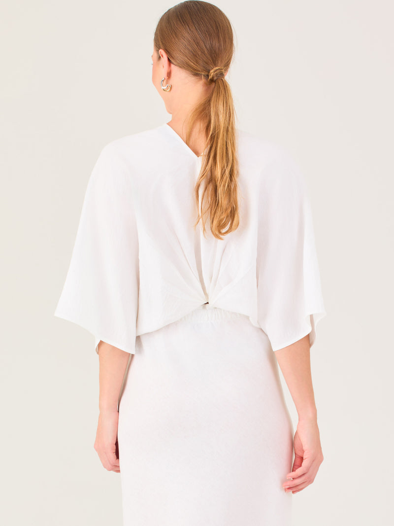 De tela ligera, escote en V y diseño suelto, es ideal para looks frescos y veraniegos. El nudo central le da un toque moderno y femenino.