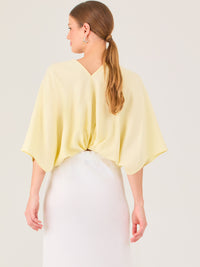 De tela ligera, escote en V y diseño suelto, es ideal para looks frescos y veraniegos. El nudo central le da un toque moderno y femenino.
