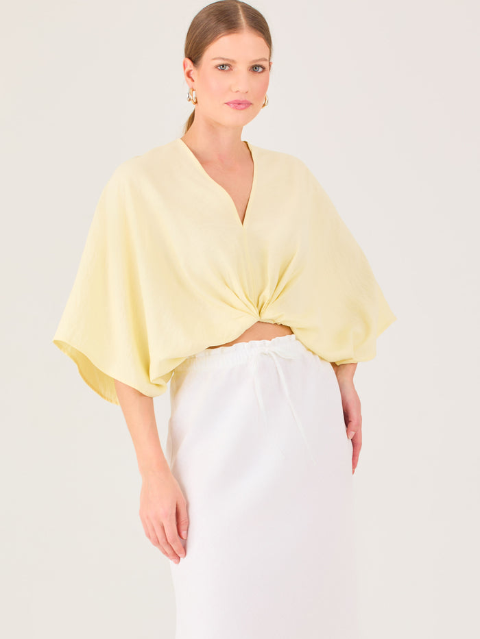 De tela ligera, escote en V y diseño suelto, es ideal para looks frescos y veraniegos. El nudo central le da un toque moderno y femenino.