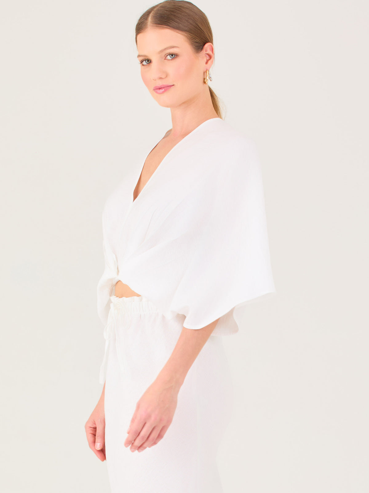 De tela ligera, escote en V y diseño suelto, es ideal para looks frescos y veraniegos. El nudo central le da un toque moderno y femenino.