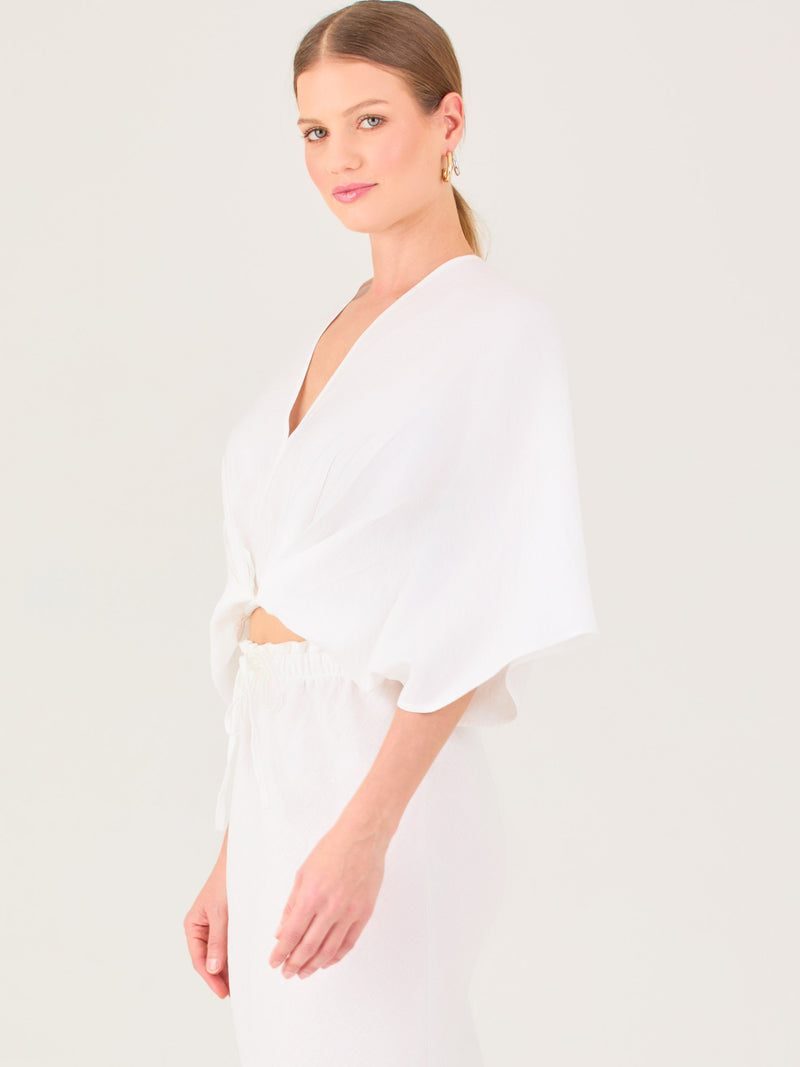 De tela ligera, escote en V y diseño suelto, es ideal para looks frescos y veraniegos. El nudo central le da un toque moderno y femenino.