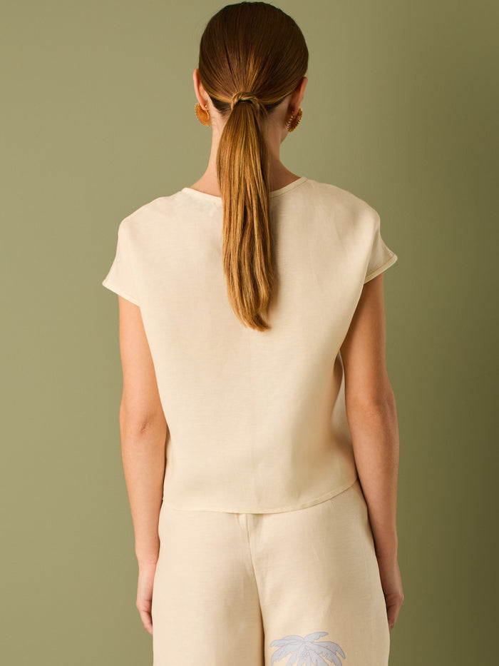 Blusa con silueta relajada y escote redondo. se destaca&nbsp; por su estampado de palmeras en tono contrastante que aporta un aire tropical y veraniego. Ideal para looks casuales con un toque fresco y divertido

Detalles:

Color: Sand

Material: 52% Lino 48% Rayón viscosa
