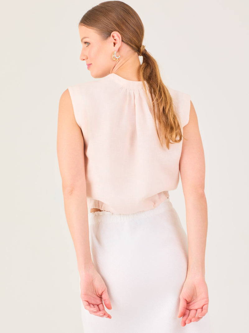 Blusa sin mangas con escote en V y botones frontales. Ajuste en la cintura con cordón, creando un efecto fruncido. Diseño ligero y femenino.

Detalles: