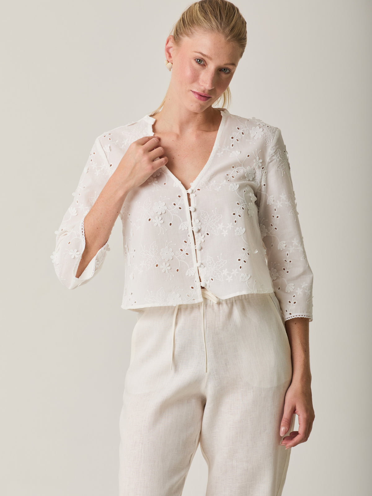 Blusa Maddie Blanco con bordado floral, botones frontales y manga tres cuartos para mujer.