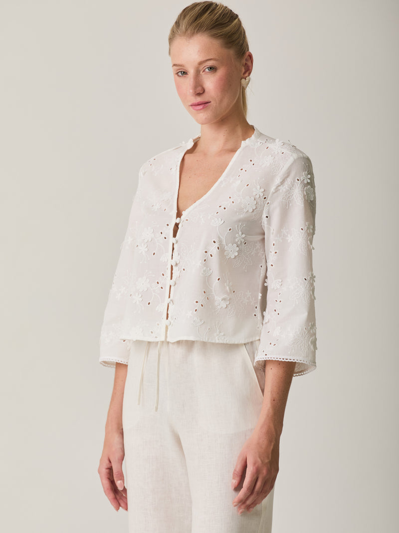 Blusa Maddie Blanco delicada con manga 3/4, diseño floral bordado y textura ligera.