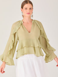 Ligera y romántica, esta blusa de textura vaporosa destaca por sus volantes en capas que aportan movimiento y fluidez. El escote en V y las mangas amplias con acabado ondulado añaden un toque delicado y sofisticado. Ideal para ocasiones especiales, cenas o estilismos casuales con un aire femenino y refinado.