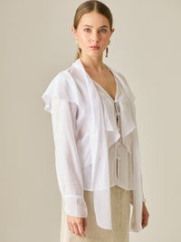 Blusa de manga larga con detalle de volantes en el escote y lazo largo para anudar. Su diseño ligero y delicado aporta movimiento y sofisticación, ideal para un look femenino con un aire romántico y moderno.

Detalles: