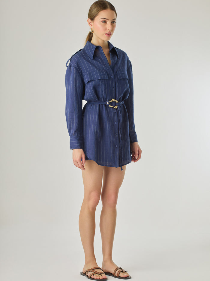 Blusa tipo camisera de manga larga con sutiles rayas y cinturón trenzado que define la figura. Su diseño ligero y relajado ofrece un estilo casual con toques elegantes, ideal para llevar con faldas o pantalones en looks versátiles y modernos.

Detalles:

Color: Navy

Material: 77% Rayon 23% Nylon

Características: Incluye cinturón a tono.