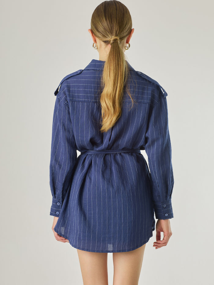 Blusa tipo camisera de manga larga con sutiles rayas y cinturón trenzado que define la figura. Su diseño ligero y relajado ofrece un estilo casual con toques elegantes, ideal para llevar con faldas o pantalones en looks versátiles y modernos.

Detalles:

Color: Navy

Material: 77% Rayon 23% Nylon

Características: Incluye cinturón a tono.