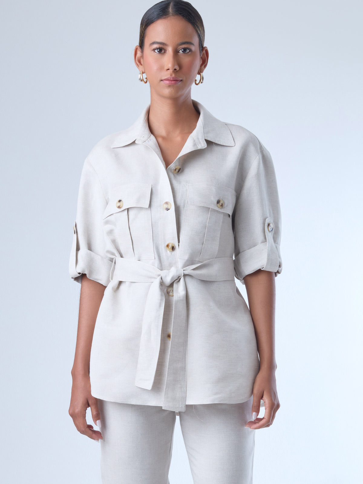 Estructurada y versátil, esta sobrecamisa de corte recto incorpora un cinturón que define la cintura y realza la silueta. Con bolsillos tipo parche en el pecho, manga con ajuste y botonadura clásica, es una prenda ideal para looks monocromáticos, estilismos urbanos o conjuntos sofisticados de inspiración utilitaria. Perfecta como pieza central de un outfit cómodo y elegante.