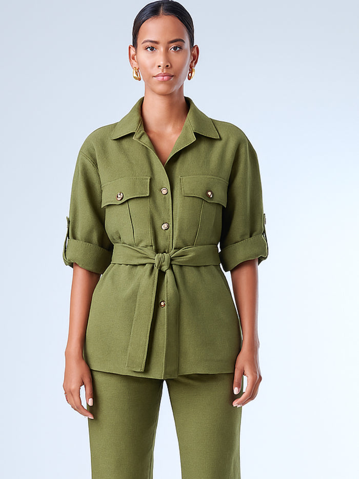 Diseñada para un look estructurado con actitud, esta sobrecamisa combina funcionalidad y estilo. Con cuello clásico, botones frontales y bolsillos de solapa, incorpora un cinturón que acentúa la cintura y realza la silueta. Las mangas pueden llevarse dobladas para un aire relajado o extendidas para un look más pulido. Ideal para outfits casuales sofisticados o conjuntos monocromáticos con carácter.