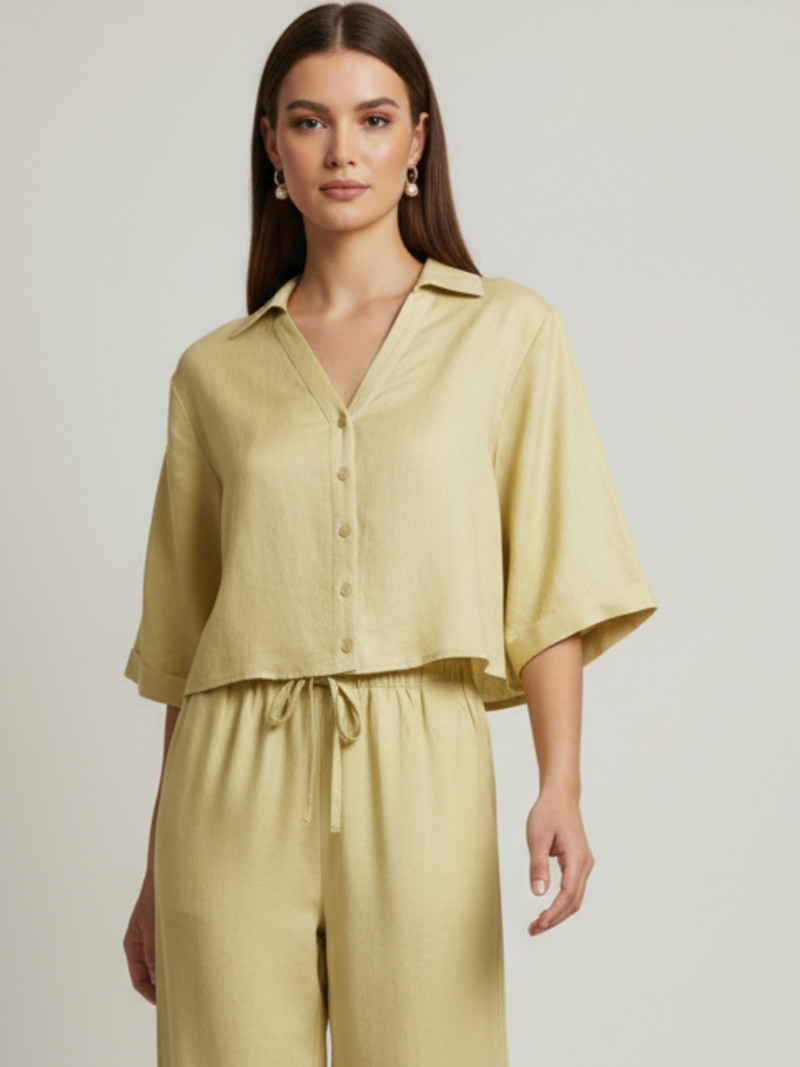 Blusa cropped, manga amplia tipo kimono y cuello camisero; botonadura frontal, ajuste relajado y caída ligera—fresca y versátil para un look casual-elegante