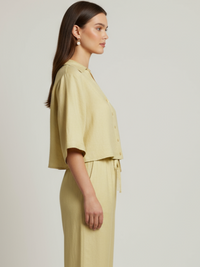 Blusa cropped, manga amplia tipo kimono y cuello camisero; botonadura frontal, ajuste relajado y caída ligera—fresca y versátil para un look casual-elegante