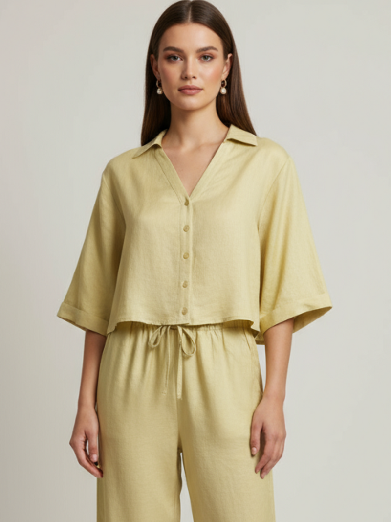 Blusa cropped, manga amplia tipo kimono y cuello camisero; botonadura frontal, ajuste relajado y caída ligera—fresca y versátil para un look casual-elegante