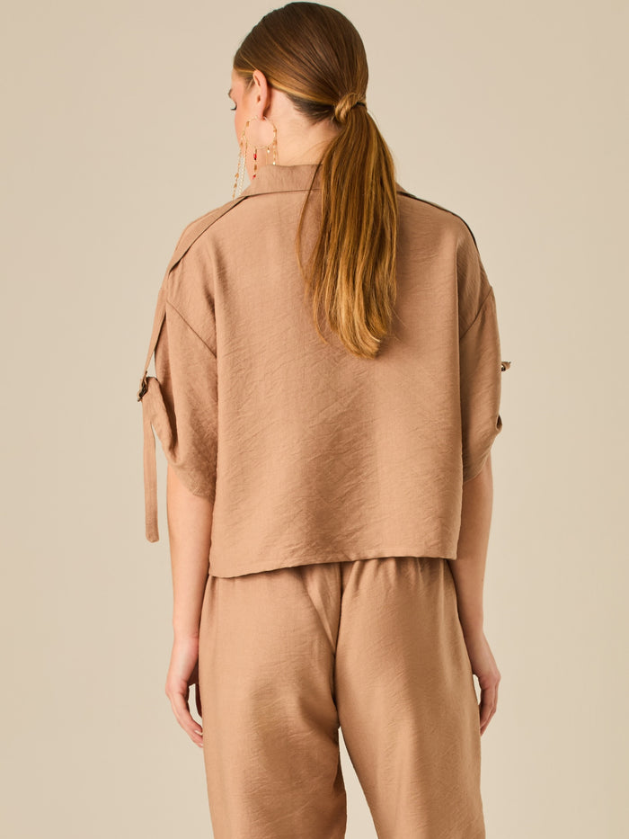 Blusa de silueta relajada con botones al frente, bolsillos tipo parche y mangas con detalle de amarre que aporta un aire desenfadado y chic. Su estilo versátil la convierte en una opción perfecta para looks casuales con un toque sofisticado.

Detalles:

Color: Cafe

Material: 90% Rayon 10% Nylon