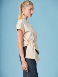 Blusa Shantall Crema elegante con corte relajado y amarre lateral decorativo.