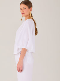 Sofisticada y atemporal, esta blusa de silueta recta se caracteriza por su escote cerrado, líneas limpias y mangas tres cuartos con efecto globo. El diseño pulido la convierte en una prenda versátil para combinar con prendas sastre o looks relajados, ideal para ambientes laborales o estilismos casuales con elegancia natural.