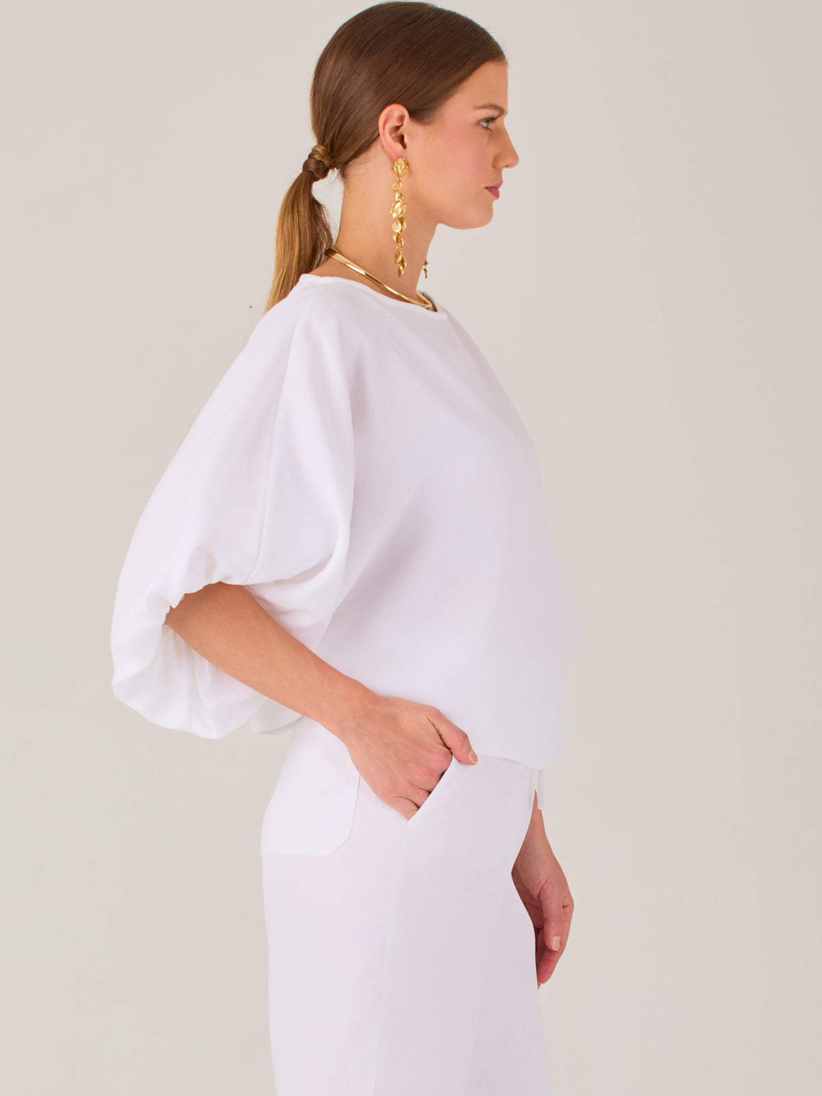 Sofisticada y atemporal, esta blusa de silueta recta se caracteriza por su escote cerrado, líneas limpias y mangas tres cuartos con efecto globo. El diseño pulido la convierte en una prenda versátil para combinar con prendas sastre o looks relajados, ideal para ambientes laborales o estilismos casuales con elegancia natural.