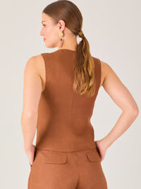 Esta blusa tipo chaleco es ideal para climas cálidos o para crear looks sofisticados con un aire casual. Presenta un corte recto ligeramente entallado que acentúa la silueta de forma sutil, y un escote en “V” que estiliza el cuello. Cuenta con una botonadura frontal compuesta por cinco botones oscuros que contrastan elegantemente con el tono neutro de la prenda. También incorpora bolsillos falsos decorativos a ambos lados del frente, que añaden un detalle sutil al diseño minimalista. Esta pieza es versátil 