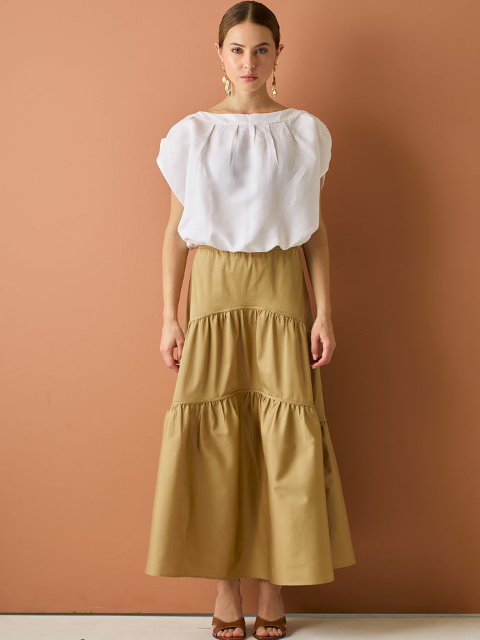 Falda larga con diseño&nbsp; de volantes suaves que aportan movimiento y volumen. Su silueta amplia y estructura liviana la hacen perfecta para un look relajado y sofisticado, ideal para combinar con blusas ligeras y crear estilismos con encanto natural.

Detalles:

Color: Camel