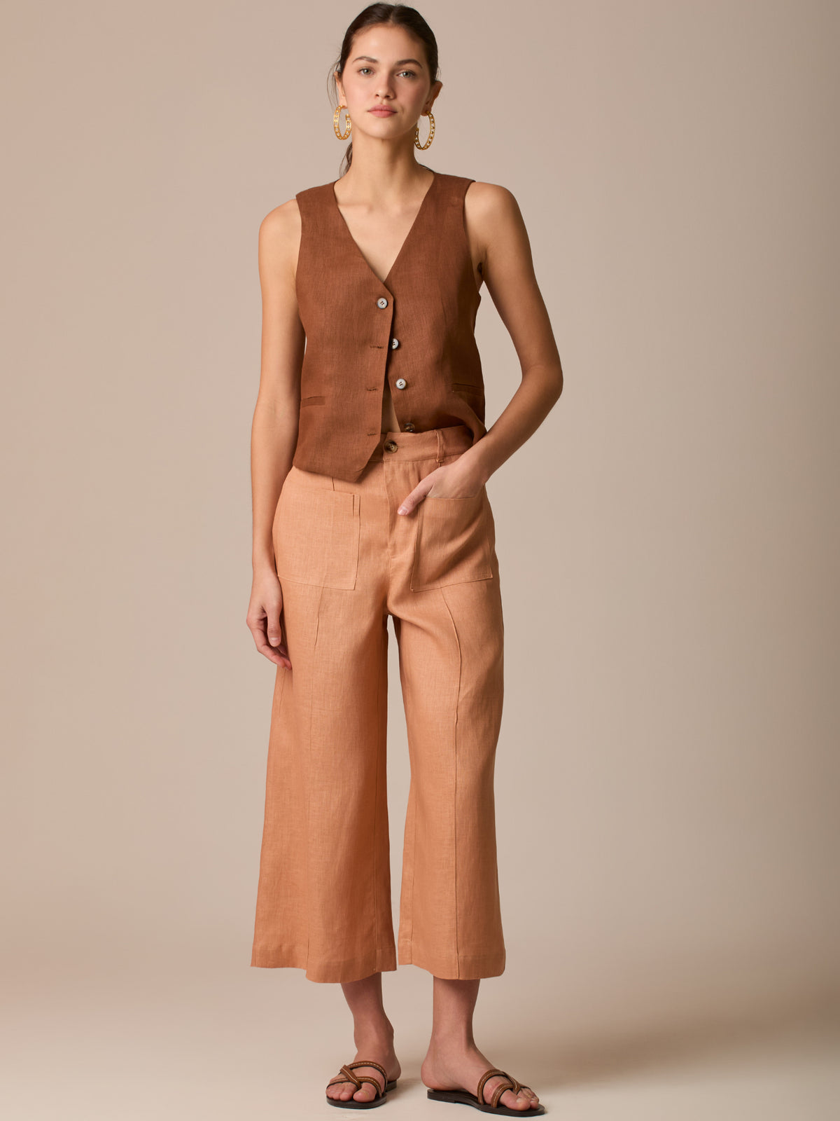 Pantalón de tiro alto con silueta culotte. Pernera amplia y recta con largo cropped al tobillo y dobladillo ancho. Pretina con botón y cierre, bolsillos de parche al frente y pinzas suaves que estilizan la cintura. Versátil y fresco para elevar looks de día o de noche

Detalles:

Color: Peach

Material: 100% Lino