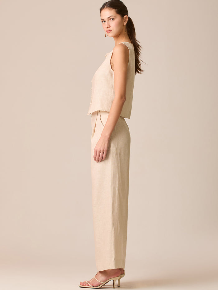 Pantalón de tiro medio con pretina plana, pinzas frontales y corte recto amplio hasta el tobillo, confeccionado en un tejido liviano de textura natural que aporta un look sofisticado y relajado