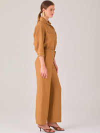 Este pantalón tiene un diseño sofisticado y moderno, confeccionado en un tono beige claro muy versátil. Presenta una silueta de pierna recta y ligeramente amplia, lo que aporta una caída elegante y cómoda. La cintura es de talle medio-alto, con cierre delantero oculto y detalles de pinzas que estilizan la figura. Incluye trabillas para cinturón y bolsillos laterales funcionales, además de costuras marcadas al frente que aportan estructura. Es una prenda ideal para looks de oficina, conjuntos monocromáticos 