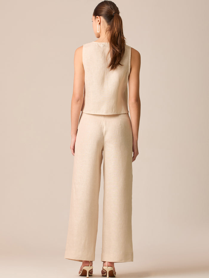 Pantalón de tiro medio con pretina plana, pinzas frontales y corte recto amplio hasta el tobillo, confeccionado en un tejido liviano de textura natural que aporta un look sofisticado y relajado