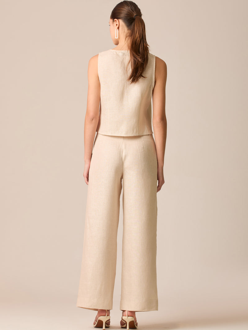 Pantalón de tiro medio con pretina plana, pinzas frontales y corte recto amplio hasta el tobillo, confeccionado en un tejido liviano de textura natural que aporta un look sofisticado y relajado