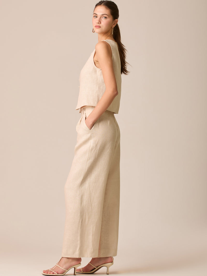 Pantalón de tiro medio con pretina plana, pinzas frontales y corte recto amplio hasta el tobillo, confeccionado en un tejido liviano de textura natural que aporta un look sofisticado y relajado
