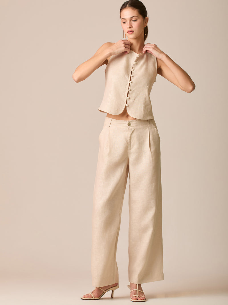 Pantalón de tiro medio con pretina plana, pinzas frontales y corte recto amplio hasta el tobillo, confeccionado en un tejido liviano de textura natural que aporta un look sofisticado y relajado