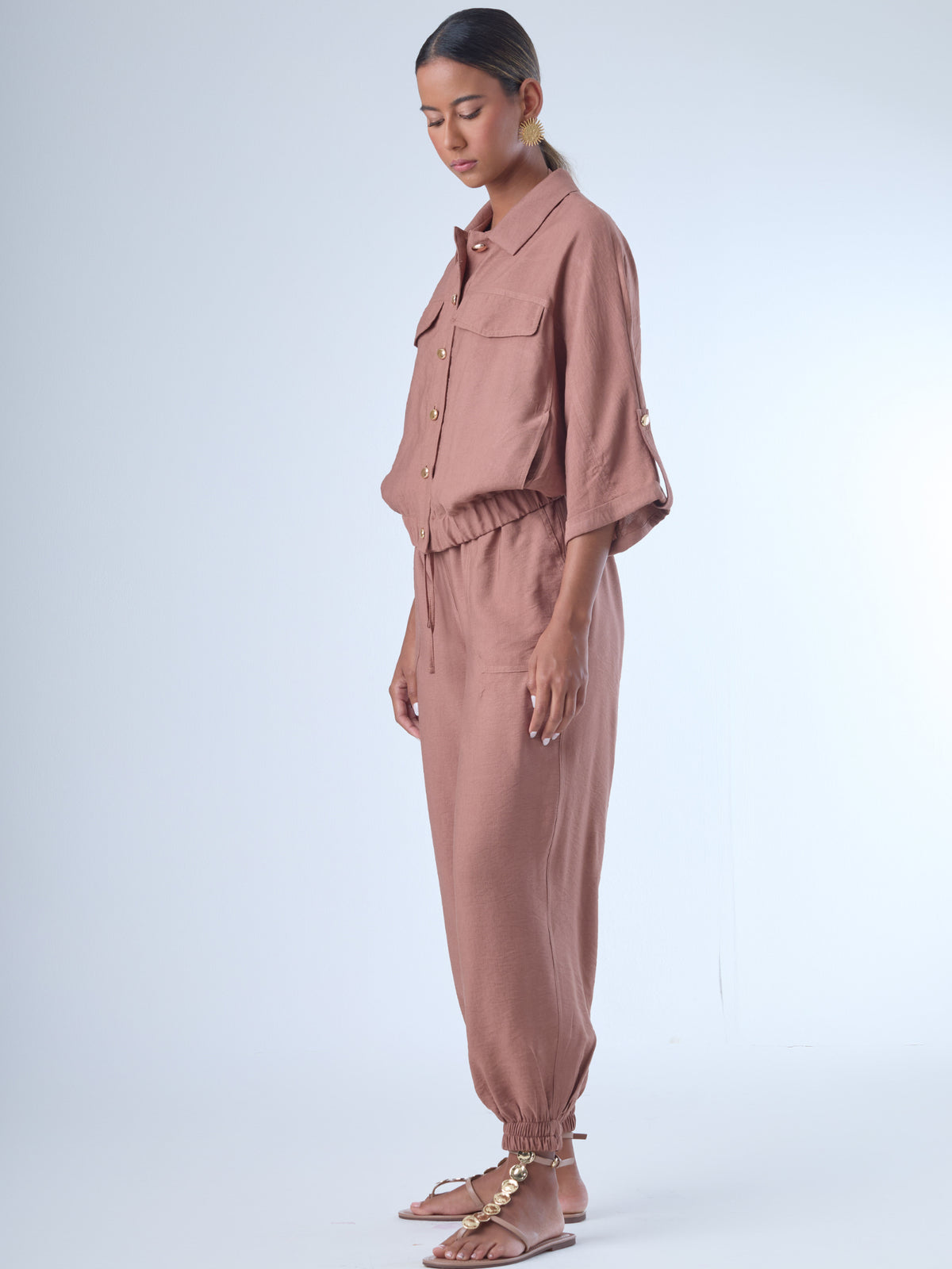 Cómodo y versátil, este pantalón tipo jogger presenta una silueta relajada con ajuste en tobillos y cintura elástica para máximo confort. Los bolsillos frontales tipo parche y la textura suave de la tela lo hacen ideal para looks casuales con un toque elevado. Perfecto para combinar con blusas fluidas o camisas estructuradas, en días de descanso o estilismos urbanos sofisticados.