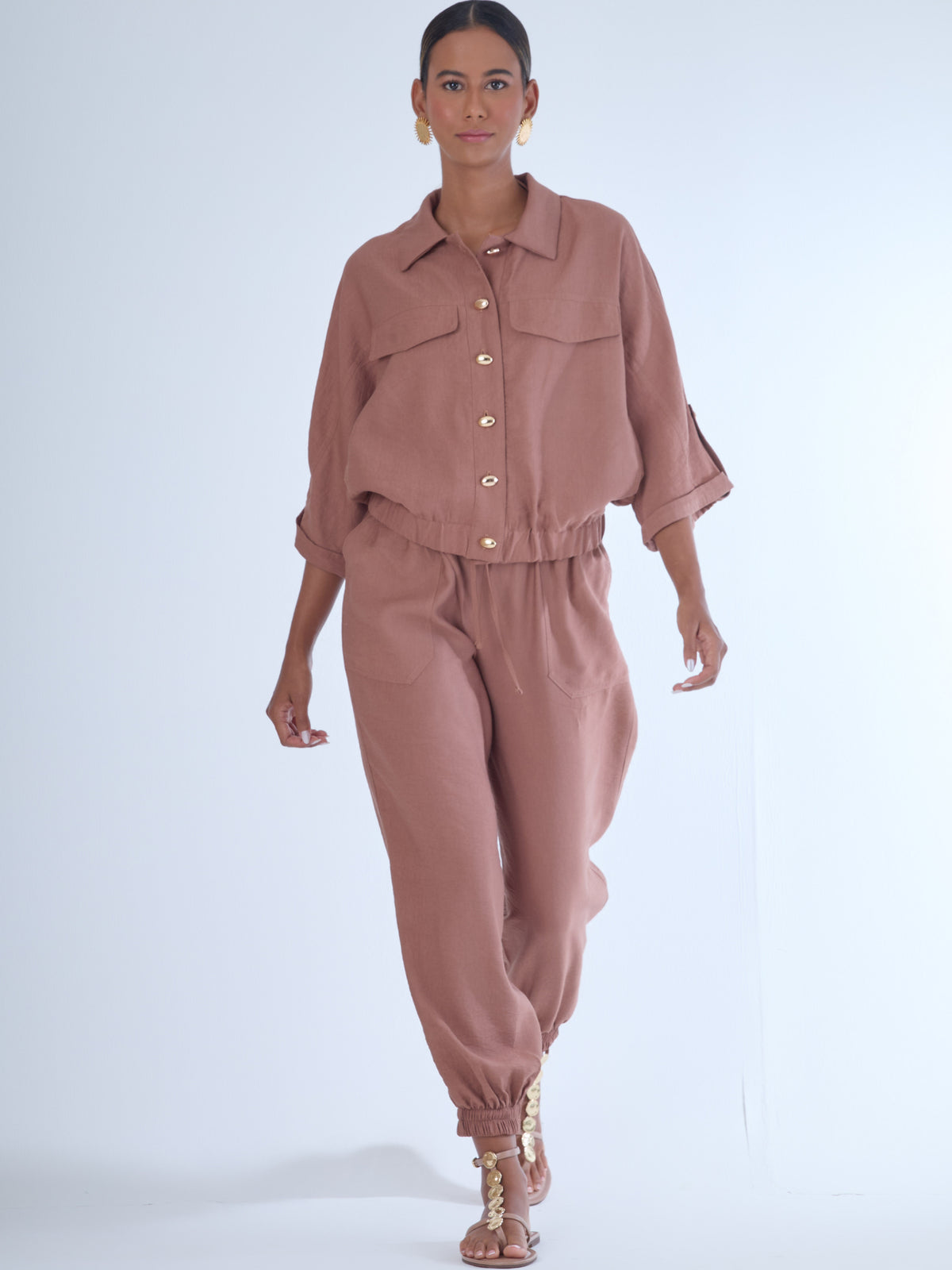 Cómodo y versátil, este pantalón tipo jogger presenta una silueta relajada con ajuste en tobillos y cintura elástica para máximo confort. Los bolsillos frontales tipo parche y la textura suave de la tela lo hacen ideal para looks casuales con un toque elevado. Perfecto para combinar con blusas fluidas o camisas estructuradas, en días de descanso o estilismos urbanos sofisticados.