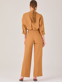 Este pantalón tiene un diseño sofisticado y moderno, confeccionado en un tono beige claro muy versátil. Presenta una silueta de pierna recta y ligeramente amplia, lo que aporta una caída elegante y cómoda. La cintura es de talle medio-alto, con cierre delantero oculto y detalles de pinzas que estilizan la figura. Incluye trabillas para cinturón y bolsillos laterales funcionales, además de costuras marcadas al frente que aportan estructura. Es una prenda ideal para looks de oficina, conjuntos monocromáticos 