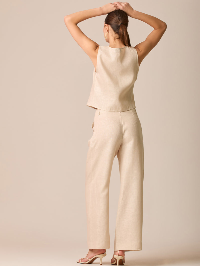 Pantalón de tiro medio con pretina plana, pinzas frontales y corte recto amplio hasta el tobillo, confeccionado en un tejido liviano de textura natural que aporta un look sofisticado y relajado