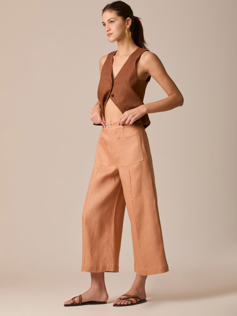 Pantalón de tiro alto con silueta culotte. Pernera amplia y recta con largo cropped al tobillo y dobladillo ancho. Pretina con botón y cierre, bolsillos de parche al frente y pinzas suaves que estilizan la cintura. Versátil y fresco para elevar looks de día o de noche

Detalles:

Color: Peach

Material: 100% Lino