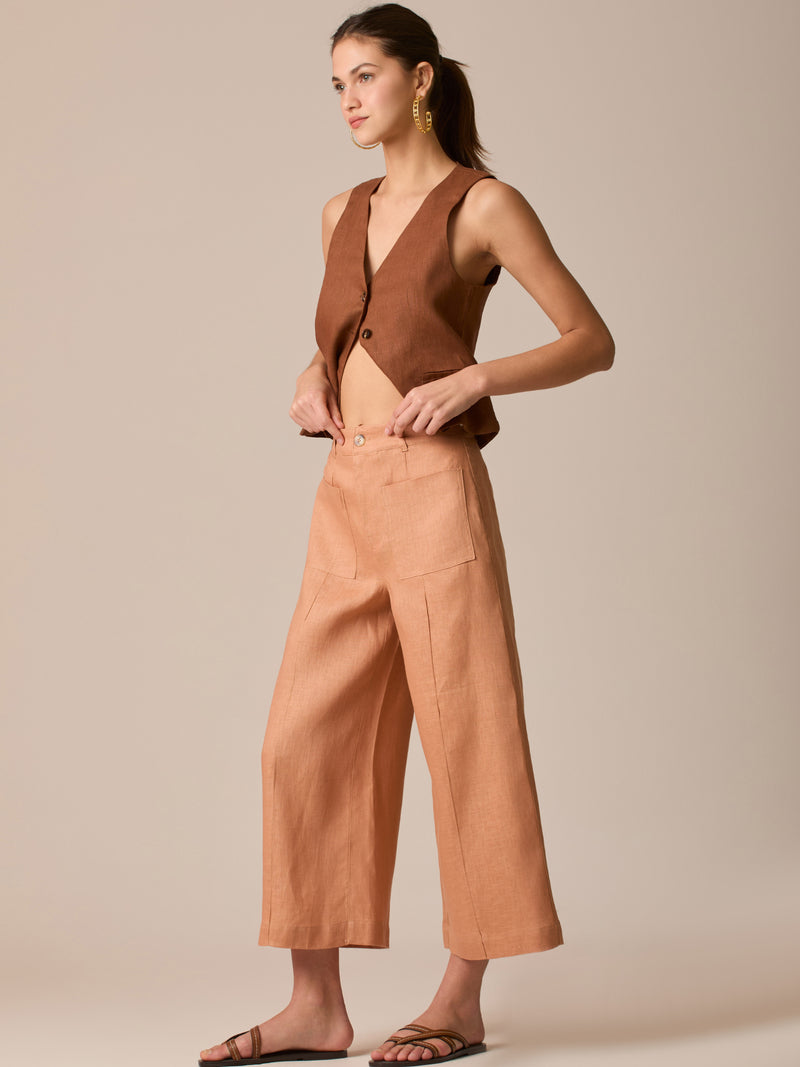 Pantalón de tiro alto con silueta culotte. Pernera amplia y recta con largo cropped al tobillo y dobladillo ancho. Pretina con botón y cierre, bolsillos de parche al frente y pinzas suaves que estilizan la cintura. Versátil y fresco para elevar looks de día o de noche

Detalles:

Color: Peach

Material: 100% Lino