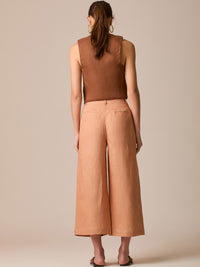 Pantalón de tiro alto con silueta culotte. Pernera amplia y recta con largo cropped al tobillo y dobladillo ancho. Pretina con botón y cierre, bolsillos de parche al frente y pinzas suaves que estilizan la cintura. Versátil y fresco para elevar looks de día o de noche

Detalles:

Color: Peach

Material: 100% Lino