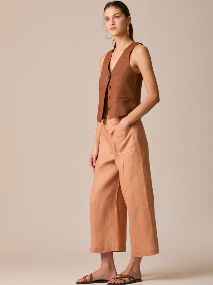 Pantalón de tiro alto con silueta culotte. Pernera amplia y recta con largo cropped al tobillo y dobladillo ancho. Pretina con botón y cierre, bolsillos de parche al frente y pinzas suaves que estilizan la cintura. Versátil y fresco para elevar looks de día o de noche

Detalles:

Color: Peach

Material: 100% Lino