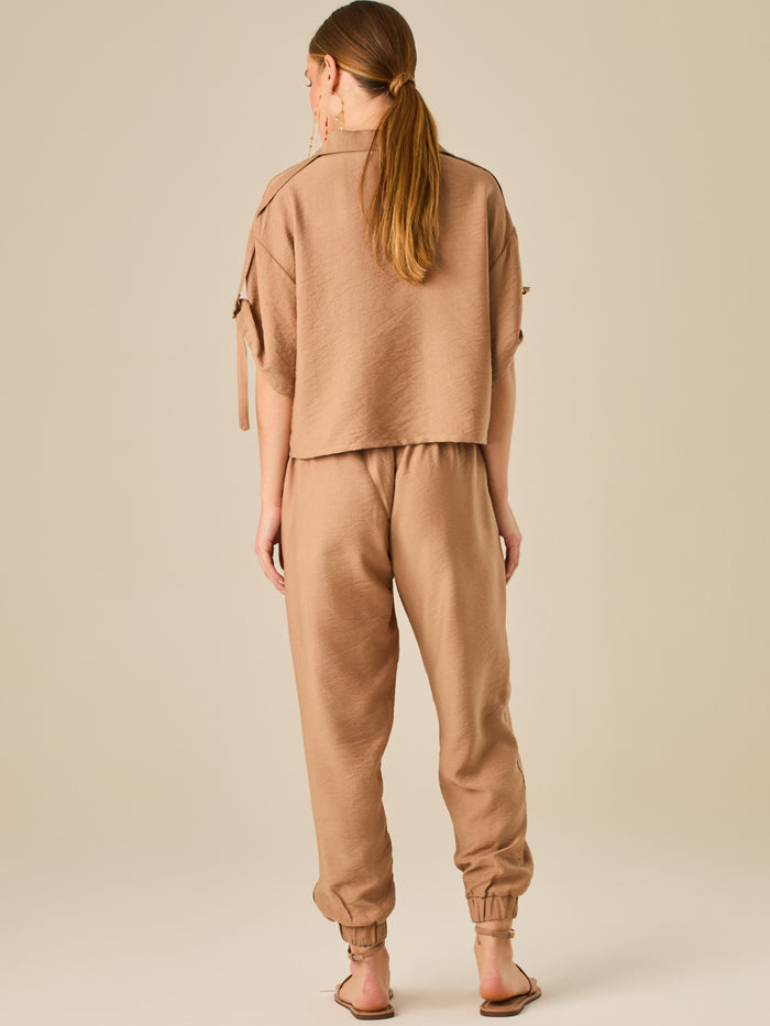 Pantalón jogger de tiro alto con pretina elástica y bolsillos frontales. Su silueta cómoda y ligera lo convierte en una prenda ideal para un estilo relajado, sin perder el toque sofisticado.

Detalles:

Color: Camel