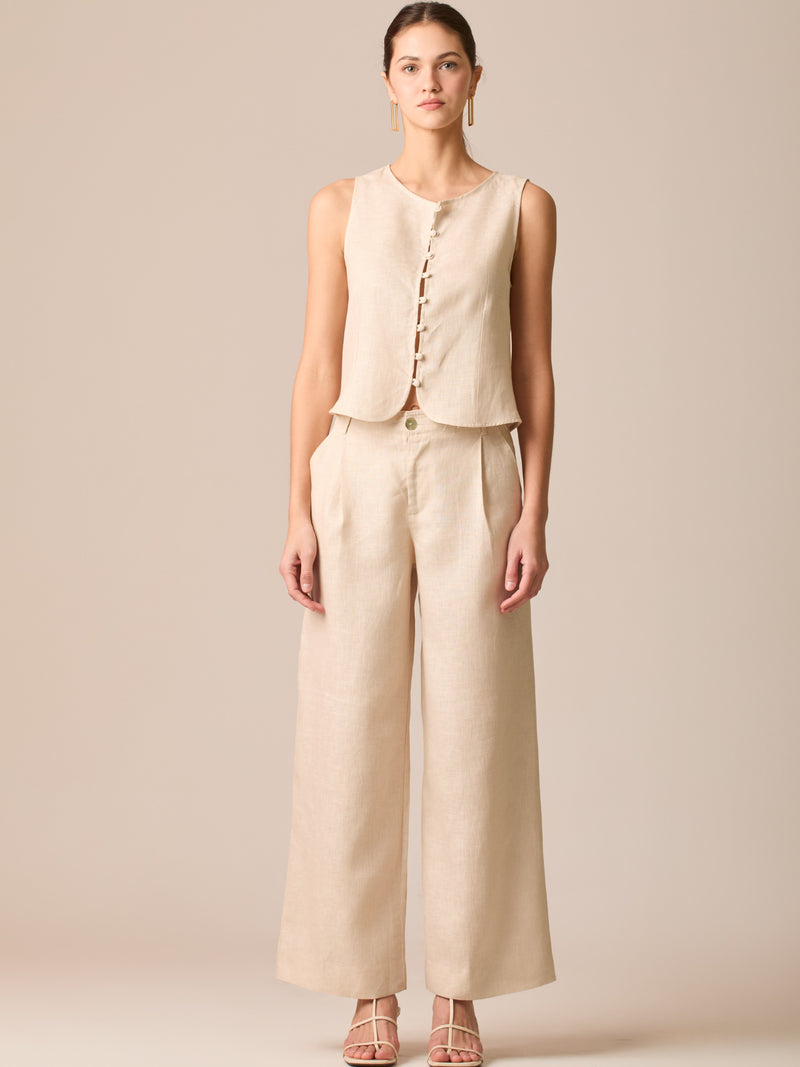 Pantalón de tiro medio con pretina plana, pinzas frontales y corte recto amplio hasta el tobillo, confeccionado en un tejido liviano de textura natural que aporta un look sofisticado y relajado