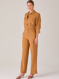 Este pantalón tiene un diseño sofisticado y moderno, confeccionado en un tono beige claro muy versátil. Presenta una silueta de pierna recta y ligeramente amplia, lo que aporta una caída elegante y cómoda. La cintura es de talle medio-alto, con cierre delantero oculto y detalles de pinzas que estilizan la figura. Incluye trabillas para cinturón y bolsillos laterales funcionales, además de costuras marcadas al frente que aportan estructura. Es una prenda ideal para looks de oficina, conjuntos monocromáticos 