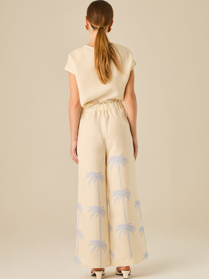 Pantalón de tiro alto con silueta amplia y pierna recta. Confeccionado en tejido liviano y suave, presenta estampado de palmeras a lo largo de ambas piernas que aporta un aire tropical y relajado. Su diseño estructurado combina comodidad y estilo, ideal para días de verano con un toque distintivo.

Detalles:

Color: Sand