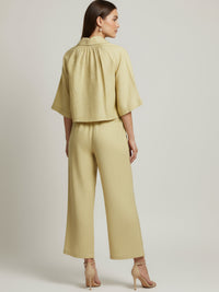 Vestido midi de tejido ligero, cuello en V con cordones y manga 3/4; silueta relajada tipo túnica con caída fluida y textura sutil—elegante y versátil de día a noche