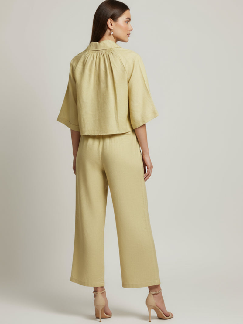 Vestido midi de tejido ligero, cuello en V con cordones y manga 3/4; silueta relajada tipo túnica con caída fluida y textura sutil—elegante y versátil de día a noche