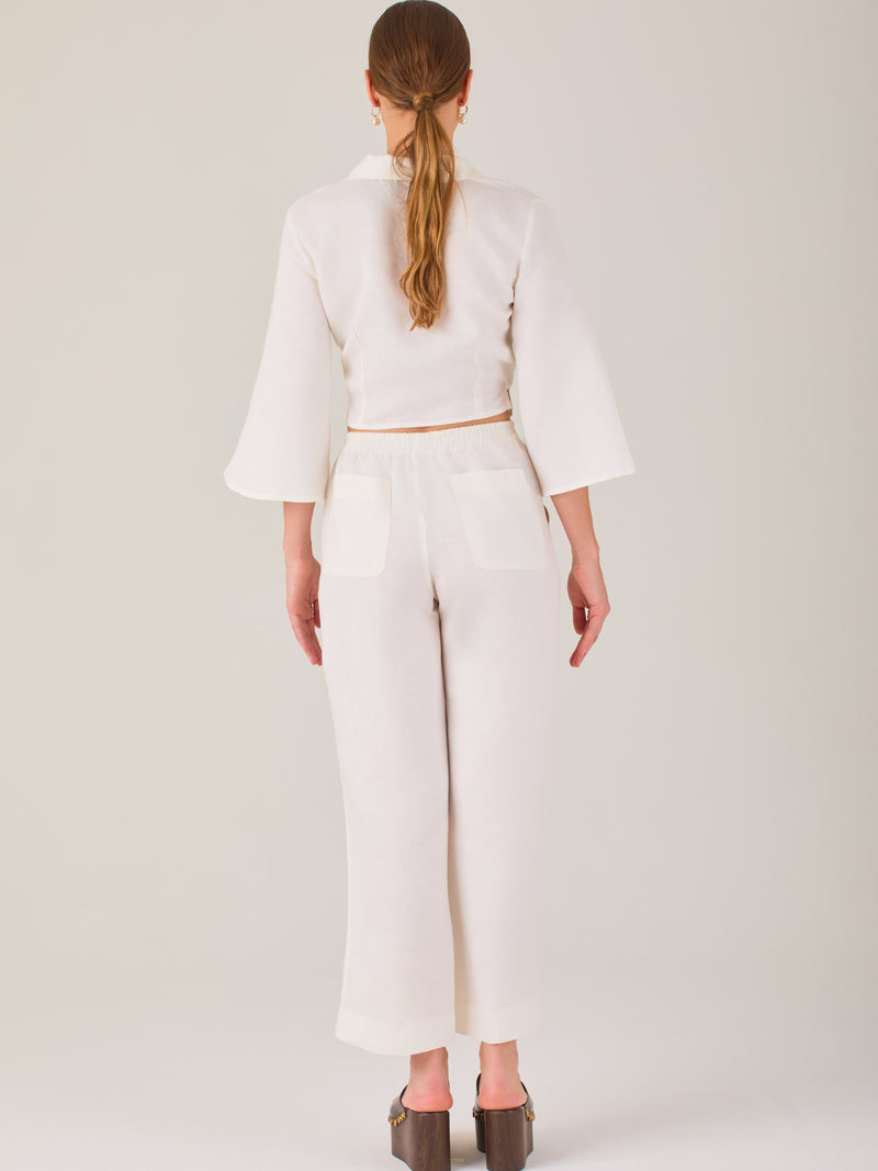 Pantalón blanco de tiro alto con pretina elástica y cordón ajustable. Corte recto y relajado, ideal para un look cómodo y fresco