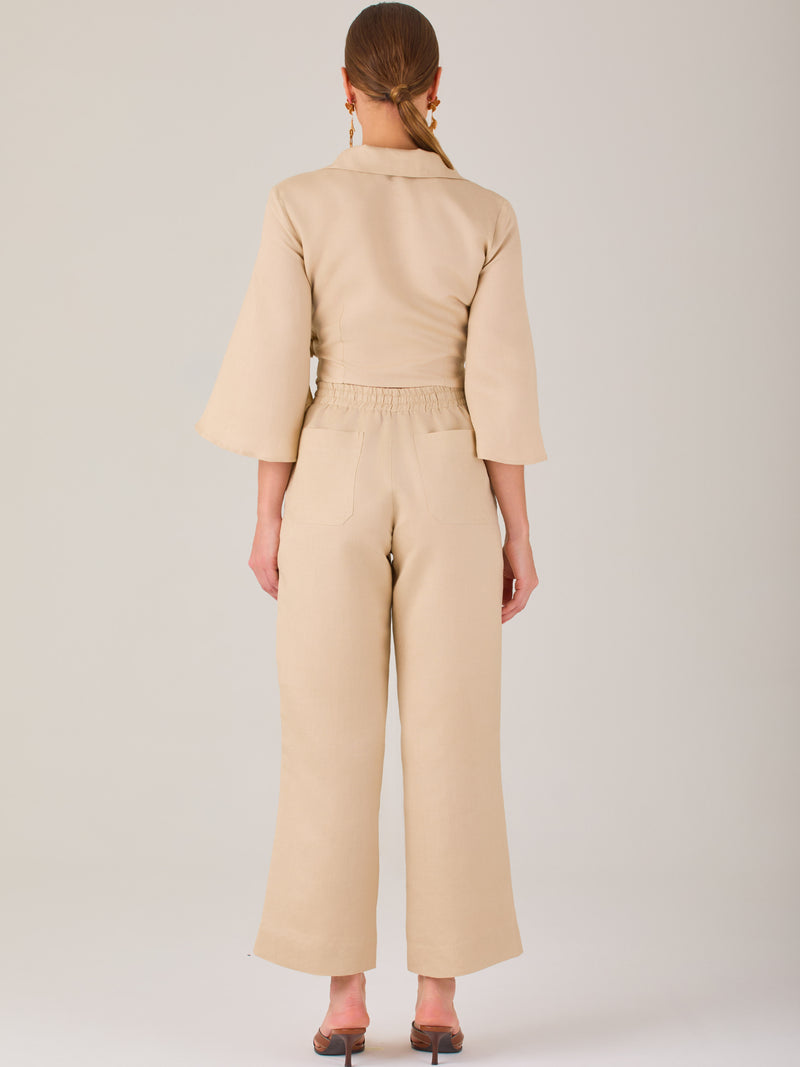 Pantalón blanco de tiro alto con pretina elástica y cordón ajustable. Corte recto y relajado, ideal para un look cómodo y fresco