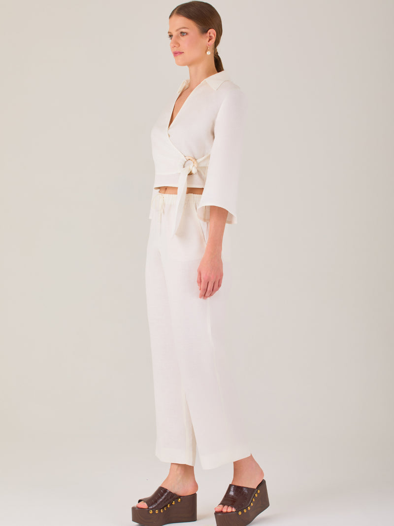 Pantalón blanco de tiro alto con pretina elástica y cordón ajustable. Corte recto y relajado, ideal para un look cómodo y fresco
